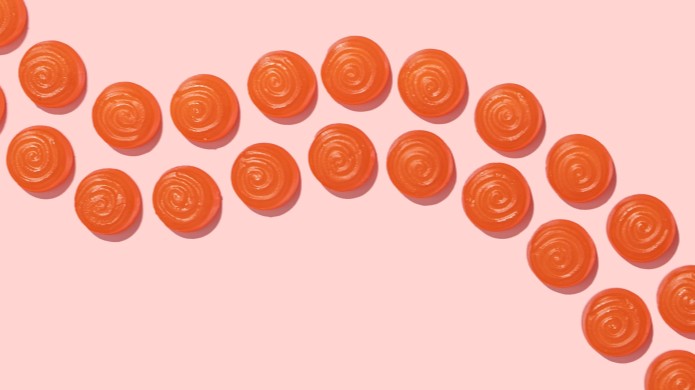pomarańczowe żelki na różowym tle