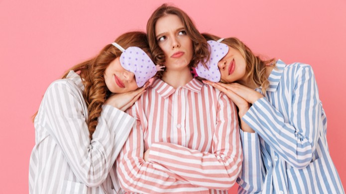 trzy kobiety w piżamkach w paski, dwie śpią, a jedna ma grymas na twarzy