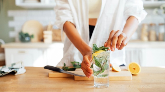 kobieta przygotowująca wodę z miętą i cytryną