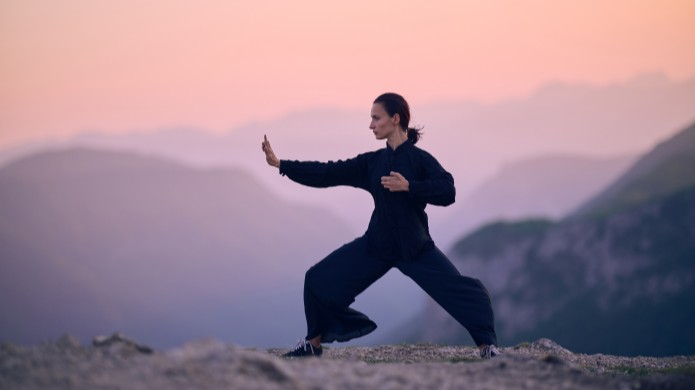 kobieta ćwicząca w górach o zachodzie słońca